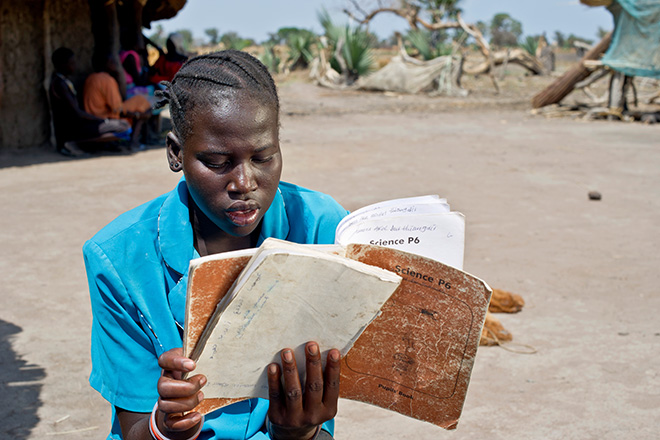 South Sudanese girl reads book