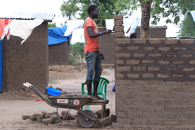 Ugandischer Mann mauert eine Latrine im Rahmen des Hygiene-Projekts