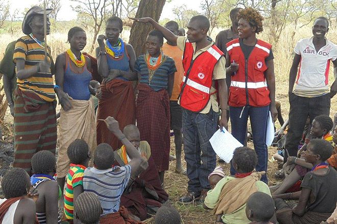 Mitarbeiter des Ugandischen Roten Kreuz vor Ort mit Flüchtlingen.