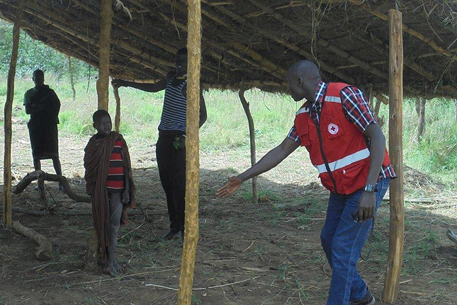 Mitarbeiter des Ugandischen Roten Kreuz hilft beim Latrinenbau.