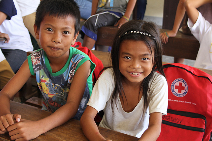 Zwei lachende philippinische Kinder in einer reparierten Schule
