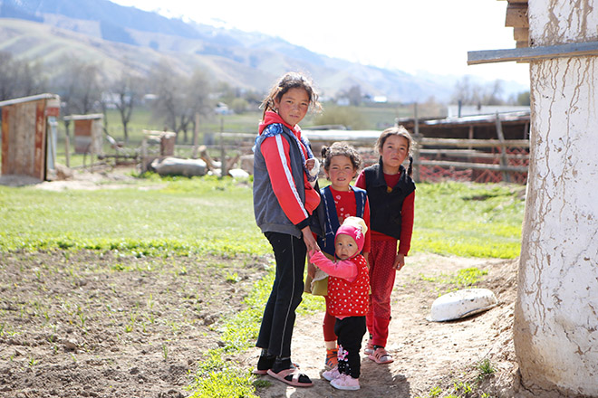 Vier kirgisische Mädchen vor Bergkette