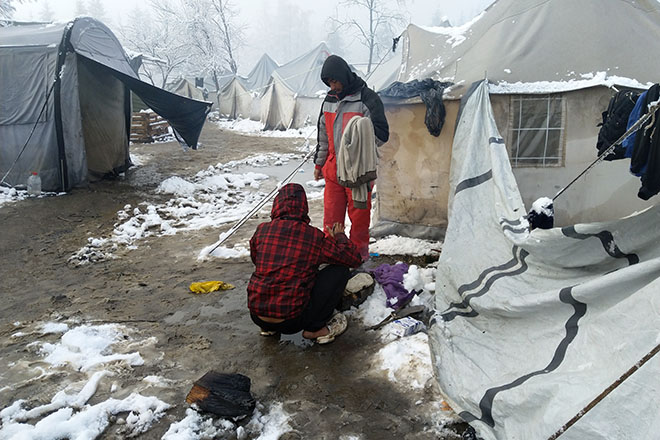 Foto: Flüchtlinge versuchen zwischen Zelten ein Lagerfeuer zu machen (Flüchtlingslager Bosnien-Herzegowina)