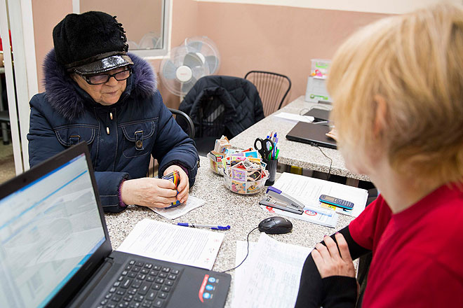 Eine Binnenvertriebene bei der Hilfeausgabe des Ukrainischen und Deutschen Roten Kreuzes