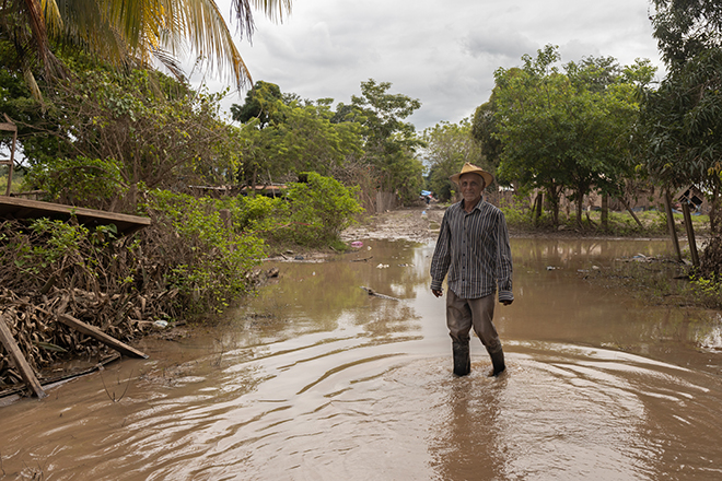 Ein älterer Mann aus Honduras steht im Überschwemmungswasser
