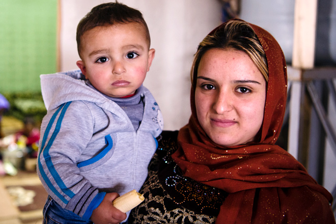 Foto: Eine junge Frau aus Syrien hält ihr Kleinkind auf dem Arm