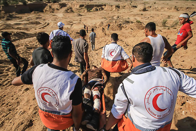 Foto aus Palästina: Vier Rothalbmondhelfer tragen einen Verletzten auf einer Trage