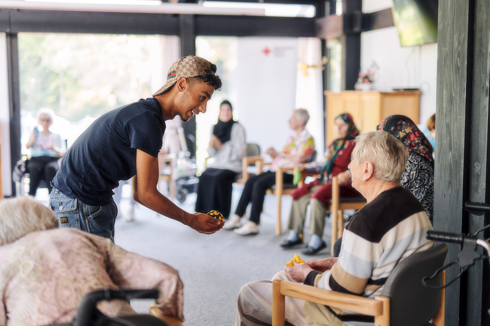 Junger Mann reicht Senior einen Ball