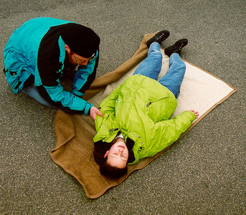 Erste Hilfe - Decke unter Betroffenen positionieren