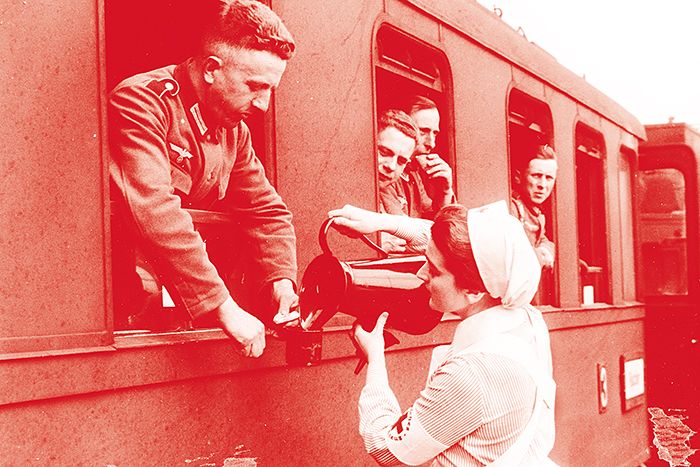 In Bahnhöfen versorgen Rotkreuzlerinnen durchreisende Soldaten mit Erfrischungen