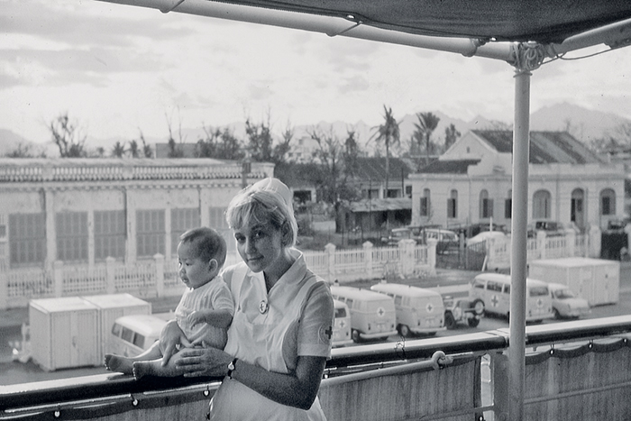 DRK-Kinderkrankenschwester mit einem Baby an Deck der MS Helgoland