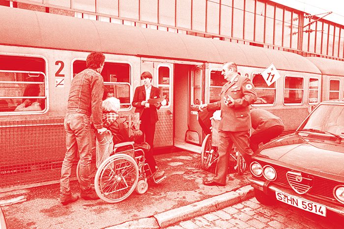 DRKler und Rollstuhlfahrer vor einem Zug
