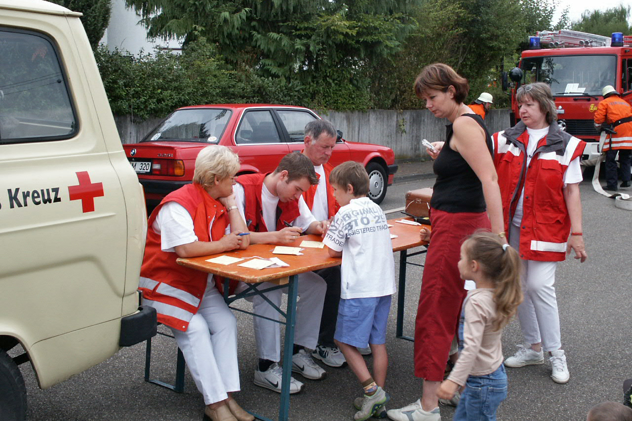 DRKler am tisch mit Kinder und Erzieherin