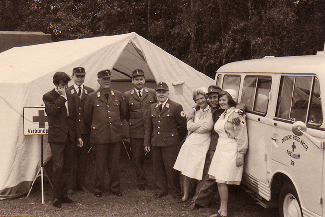 Gruppe Rotkreuzler vor Zelt und Einsatzwagen 1965