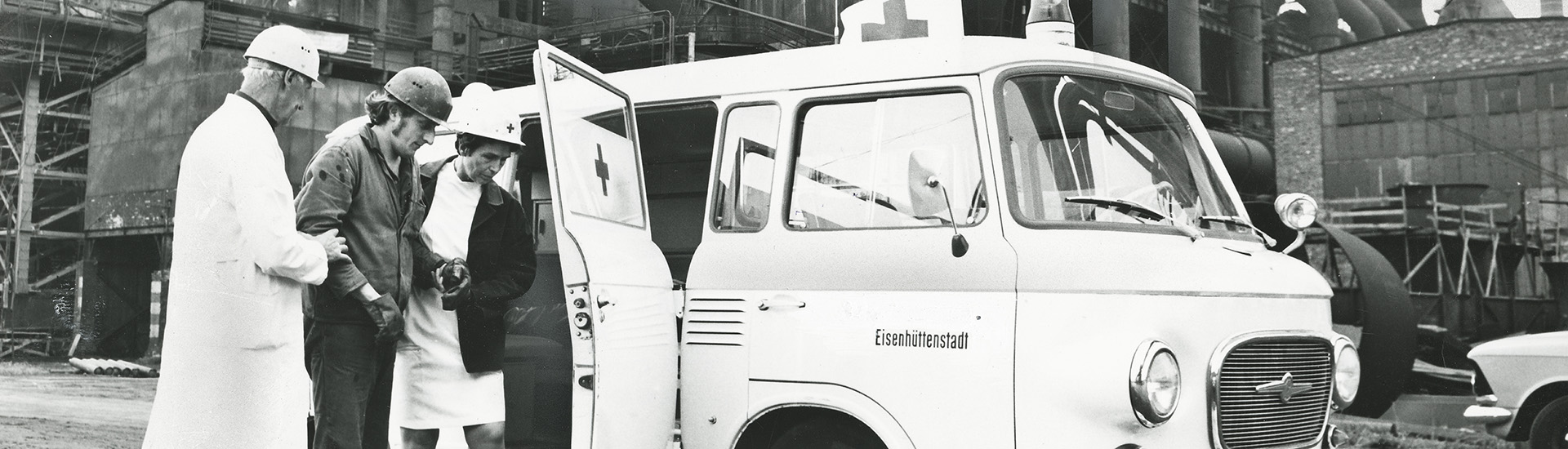 historisches Foto: Einsatzfahrzeug und Helfer im Stahlwerk Eisenhüttenstadt