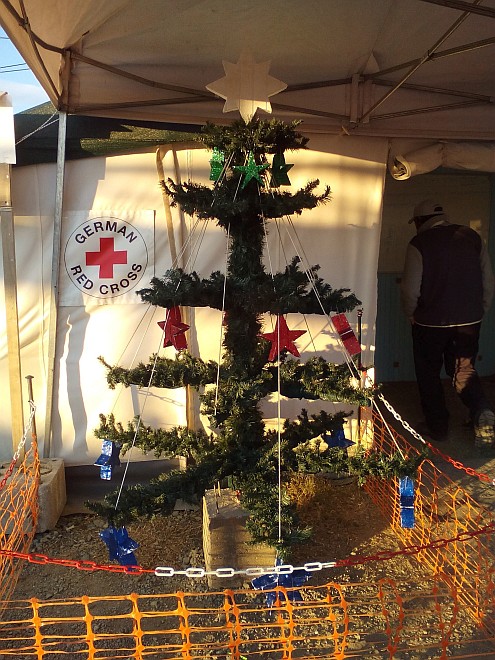 Geschmückter Nadelbaum im Zelt mit DRK-Logo