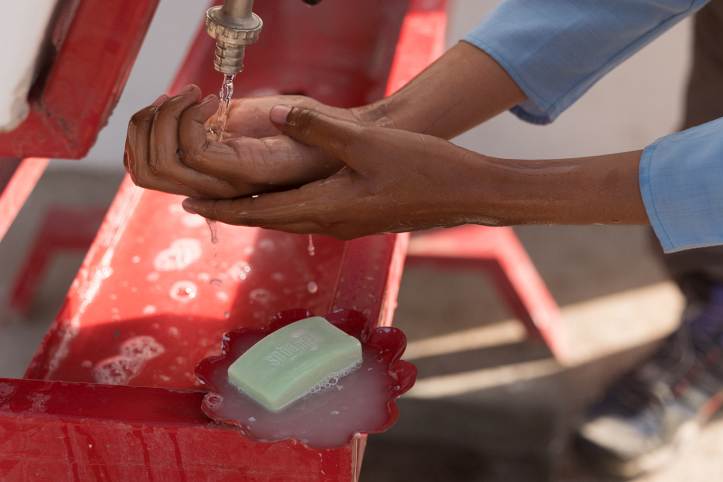 Hände unter Wasserhahn mit Seife