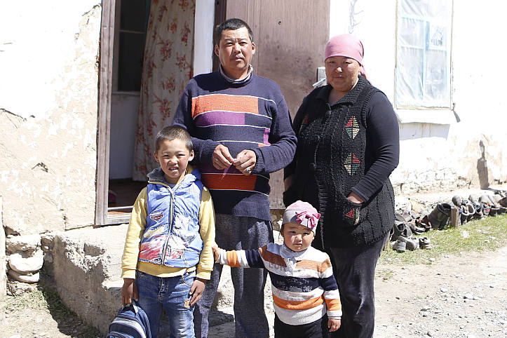 Familie in Kirgistan vor ihrem maroden Haus