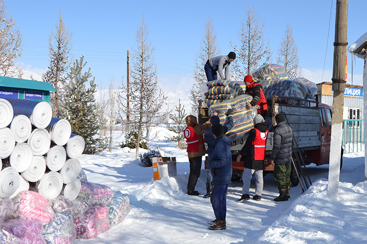 Helfer laden Winterhilfsgüter von LKW ab
