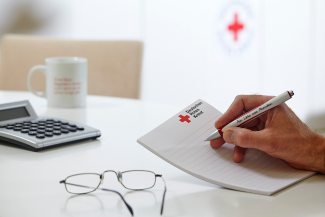 Deutsches Rotes Kreuz, DRK, Symbol, Symbolfoto, Taschenrechner, Tasse, Brille, Werbemittel, Büromaterial