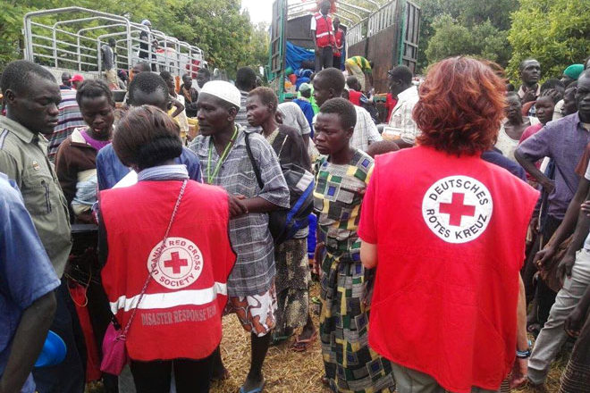 Rotkreuzmitarbeiter und südsudanesische Flüchtlinge
