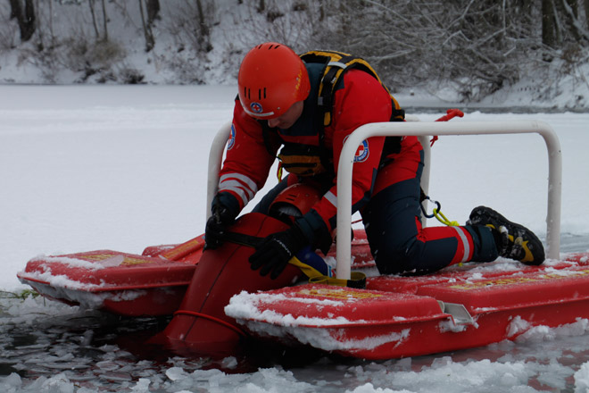 Eine Person ist nach Betreten einer Eisfläche eingebrochen und erhält Erste Hilfe