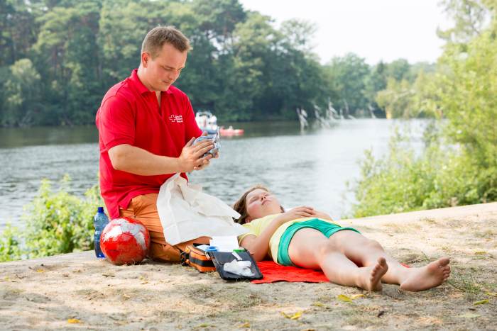 Was-tun-bei-Hitzschlag Ersthelfer mit Mädchen am Strand
